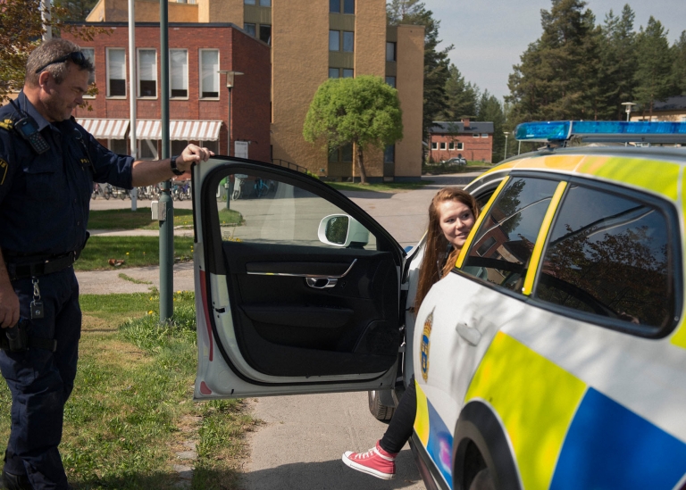 Bild på deltagare som kliver ur en polisbil